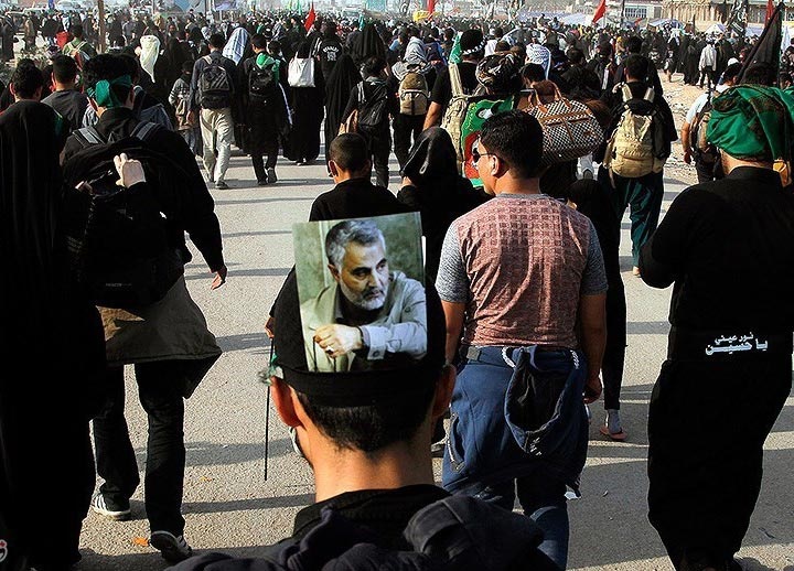 حمل تصویر قاسم سلیمانی و پرچم ایران توسط زائران حرم حسینی/ عکس